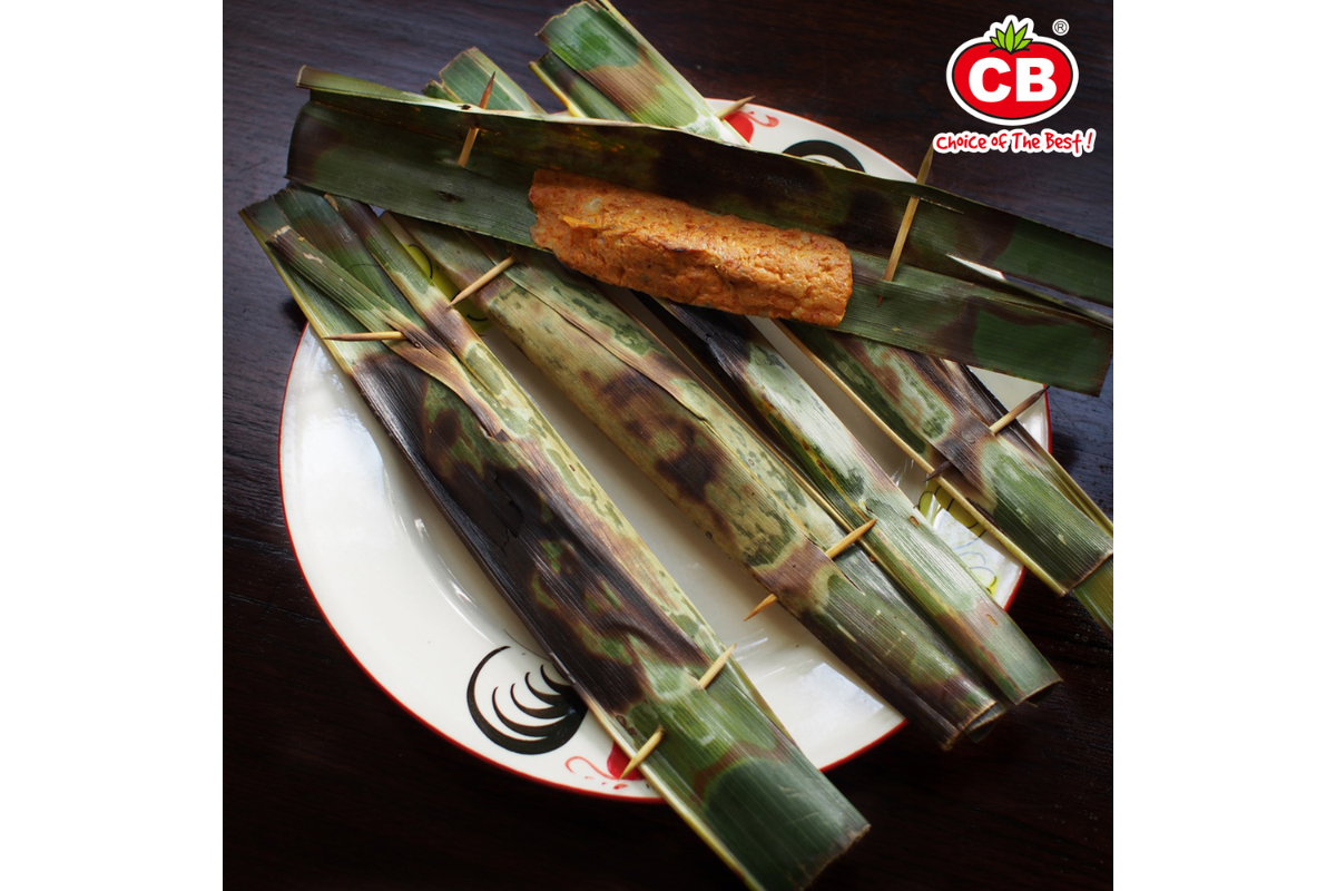 Food item wrapped in green leaves on a white plate with a CB brand logo in the corner.
