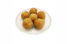 Five round, crispy cream puffs on a white plate with a white background