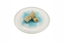 Two double layer milk roll on a round ceramic plate with a blue design on a white background