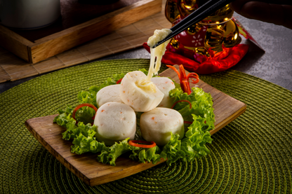 fish call with cheese on a wooden plate with chopsticks and a decorative background