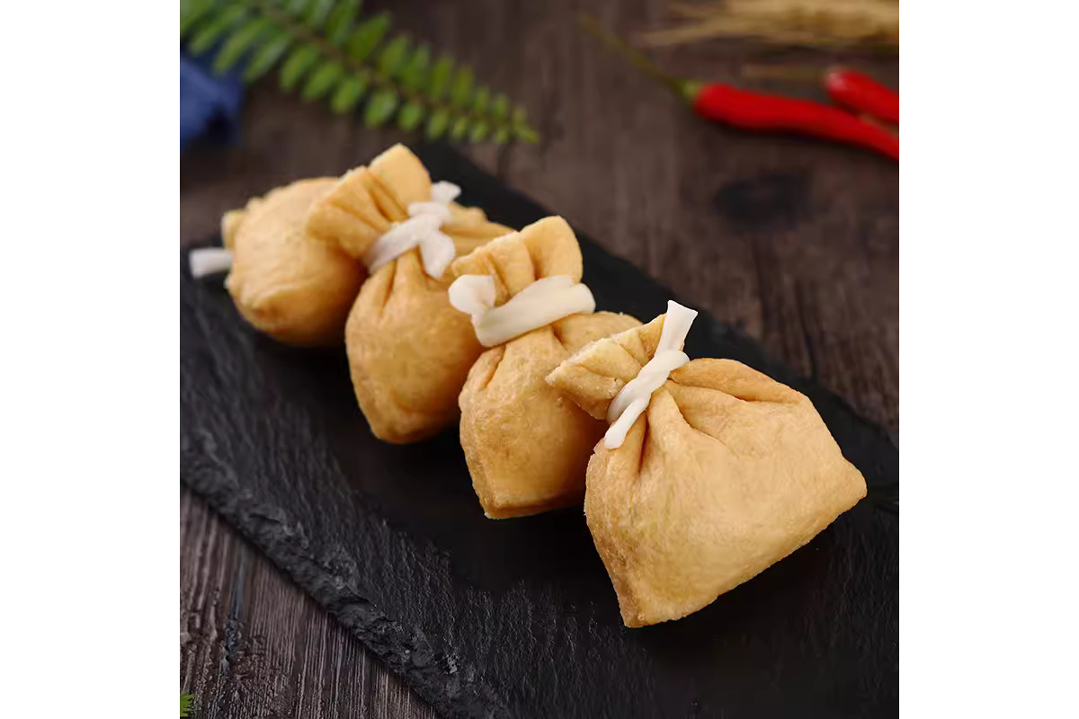 Four fish roe fortune bag tied with string on a dark surface with a blurred background