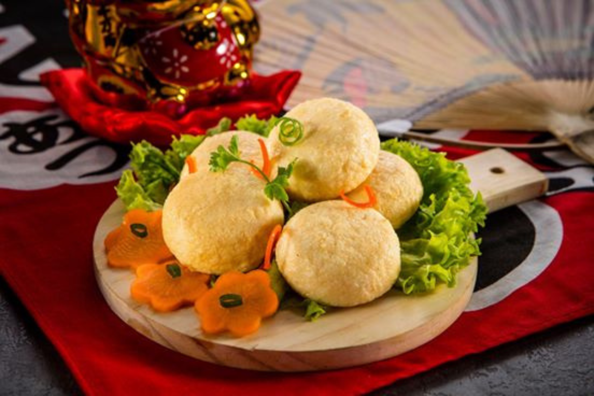 fish tofu on a wooden board with vegetables on a decorative tablecloth