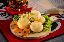 fish tofu on a wooden board with vegetables on a decorative tablecloth