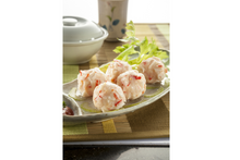 Plated lobster ball on a bamboo mat with a bowl in the background