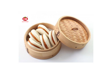 Bamboo steamer with buns on a white background