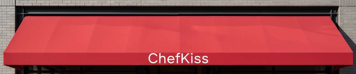 Red awning with 'ChefKiss' branding on a building exterior.